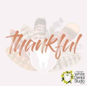 The word thankful spans across White Dental Studio's logo, that resembles a turkey.