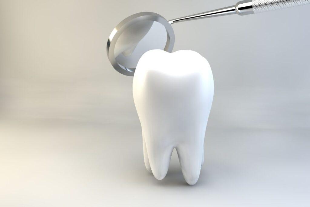 Magnifying glass examining a white tooth model, symbolizing dental checkups and oral hygiene care.